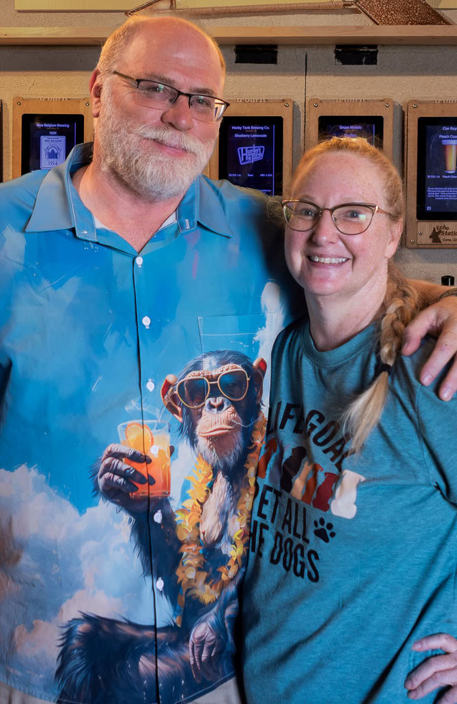 Lori and Brian, the owners of Echo Station, in front of the tap wall